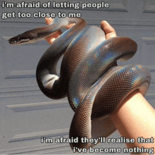 a person holding a snake with a caption that says i 'm afraid of letting people get too close