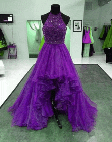 a mannequin wearing a purple high low dress