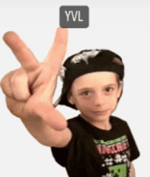 a young boy wearing a hat and a t-shirt with the word yvl on it