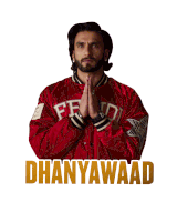 a man in a red jacket has his hands folded in front of a sign that says dhanyawaad