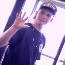 a young man wearing a purple shirt and a black hat with a red white and blue stripe on it