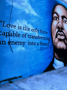 a painting of a man with the words " love is the only force capable of transforming an enemy into a friend " on it