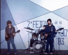 a group of people playing instruments in front of a sign that says 2 festival de la nov 83