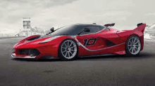 a red ferrari fxx k is parked on the side of a road .