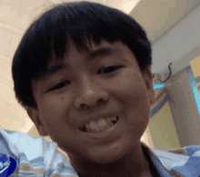 a close up of a young boy 's face with a striped shirt on