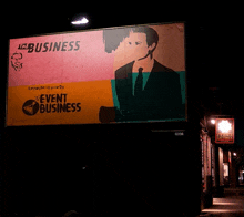 a billboard for event business is lit up in the dark