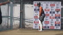 a cricket player stands in front of a sign that says ' paytm india vs england test series 2021 '