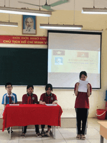 a girl stands in front of a projector screen that says dai hoc chi douta