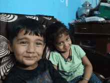 a boy and a girl are sitting on a couch and smiling for a picture