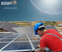 a man wearing a hard hat is working on solar panels with the words solar power solutions behind him