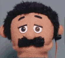 a stuffed animal with a mustache and headphones on it .