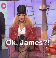 a woman in a top hat is sitting in a chair with the words ok james written on it