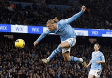 a soccer player jumps in the air to kick the ball during a game