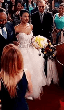 a bride and groom are walking down the aisle at their wedding .