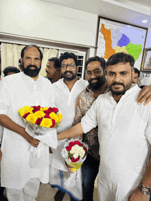 a man holding a bouquet of flowers poses for a photo with other men