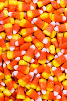 a pile of orange and yellow candy corn sitting on top of each other