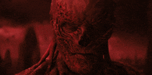 a close up of a red monster 's face with a dark background