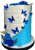 a blue and white cake with butterflies and blue roses