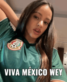 a woman wearing a green shirt that says " viva mexico wey " on it