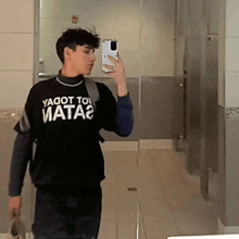 a young man is taking a picture of himself in a bathroom mirror with a shirt that says ya got to mata2