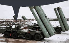 a row of military vehicles are parked in a snowy area