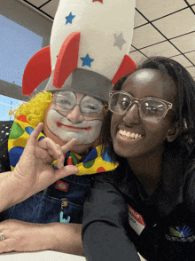 a woman wearing a name tag that says hello is posing with a clown