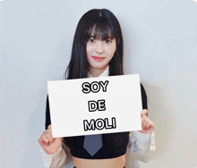 a girl is holding a sign that says soy de moli