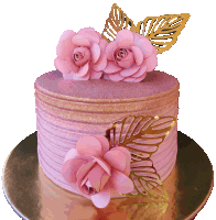 a pink and gold cake with pink flowers and gold leaves