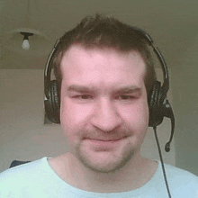 a man wearing headphones and a microphone is smiling