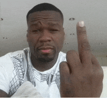 a man wearing a white shirt is giving the middle finger