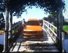 an orange car is parked on a wooden bridge with a california license plate that says jcw