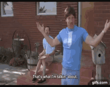 a man in a blue shirt and tie is standing in front of a brick house talking to another man .