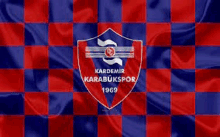 a red , blue and white checkered flag with a shield on it .