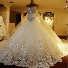 a white ball gown with a veil is on a mannequin