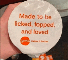 a person is holding a container of jem 's yogurt that says made to be licked topped and loved