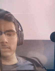 a man wearing headphones and glasses is looking at the camera