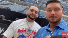 two men are posing for a picture and one has a shirt that says subway series