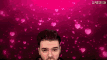 a man blowing a kiss in front of a pink background with the words supergredin