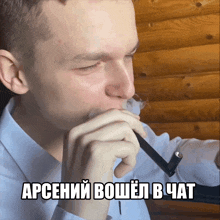 a man is smoking an electronic cigarette with a foreign language caption above him