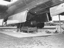 a black and white photo of a bomber sitting on top of a runway .