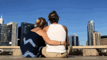 a man and a woman are looking at a city skyline with a building in the background that says ' chase '