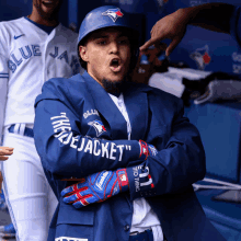 a blue jays baseball player is wearing a jacket that says " blue jacket "