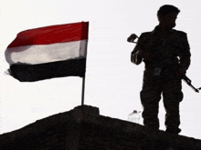 a soldier stands in front of a flag with a bottle of water in front of him