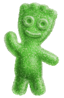 a green gummy bear with a smiling face is standing on a white background .