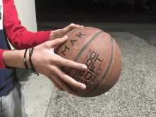 a person is holding a basketball with the word mak on it