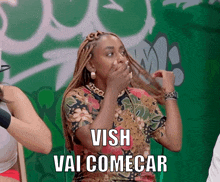 a woman covering her mouth with her hands and the words " vish vai comecar " written below her