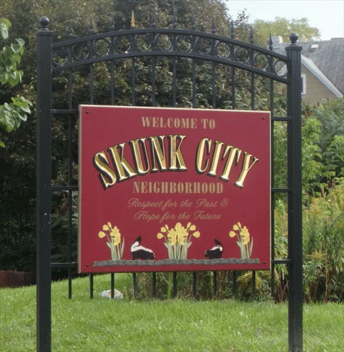 a welcome to skunk city neighborhood sign