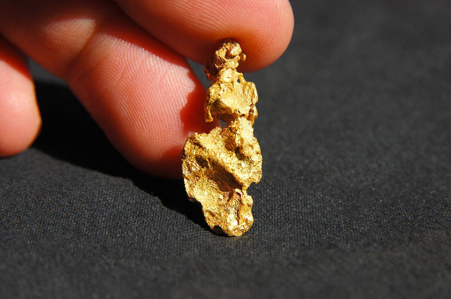 Homem mostra pepita de ouro extraída em mina em Minas Gerais