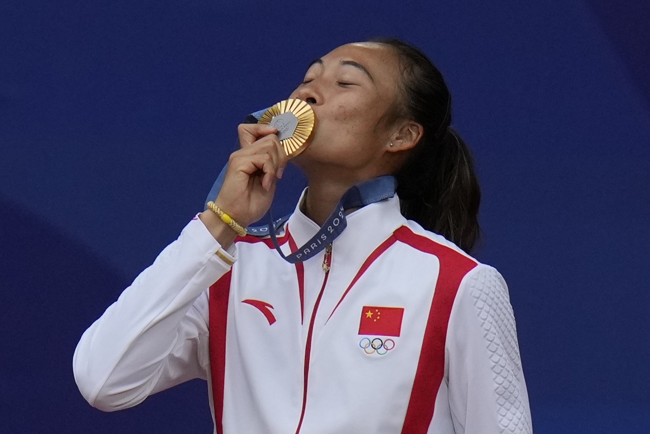 China's Zheng Qinwen kisses her gold medal after defeating Croatia's Donna Vekic in the women's singles tennis final at the Roland Garros stadium at the Summer Olympics in Paris, France, August 3, 2024. /CFP