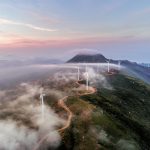 Mountain with multiple wind turbines.